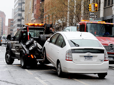 Cape Car tow truck hauling a junk car